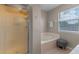 Bathroom with a soaking tub, glass-enclosed shower, and a window for natural light at 10435 Eastpark Lake Dr, Orlando, FL 32832