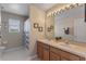 Bright bathroom with double sinks and framed mirrors above wood cabinetry at 10435 Eastpark Lake Dr, Orlando, FL 32832