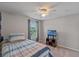 Cozy bedroom with a twin bed, ceiling fan and a view to the outdoors at 10435 Eastpark Lake Dr, Orlando, FL 32832