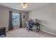 Neutral bedroom featuring a ceiling fan, plush carpet, and a window offering natural light, complete with a workspace at 10435 Eastpark Lake Dr, Orlando, FL 32832