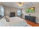 This bedroom features a ceiling fan, a TV, and coordinating grey furnishings at 10435 Eastpark Lake Dr, Orlando, FL 32832