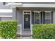 Close-up of the front door with decorative wreath, sidelights, and manicured hedges at 10435 Eastpark Lake Dr, Orlando, FL 32832