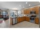 Open-concept kitchen featuring stainless appliances, tile flooring, and granite countertops with dining area at 10435 Eastpark Lake Dr, Orlando, FL 32832