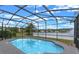 Screened in pool overlooks the lake with a fountain for a relaxing outdoor retreat at 10435 Eastpark Lake Dr, Orlando, FL 32832