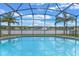 Screened-in pool area with views of the lake and fountain, a tropical paradise at 10435 Eastpark Lake Dr, Orlando, FL 32832