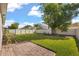 Lush backyard with a paver patio, a green lawn, a white fence, and mature shade trees at 1109 Castlevecchio Loop, Orlando, FL 32825