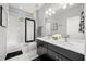 Stylish bathroom featuring double sinks, a white countertop, black cabinets, and modern fixtures at 1109 Castlevecchio Loop, Orlando, FL 32825