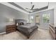 Comfortable bedroom with a ceiling fan, tray ceiling and large windows that let in plenty of light at 1109 Castlevecchio Loop, Orlando, FL 32825