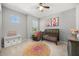 Bedroom with Flamingo art, crib, modern wallpaper, a round rug, and comfortable armchair at 1109 Castlevecchio Loop, Orlando, FL 32825