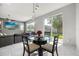 Bright dining area features a round table with modern pendant lighting and sliding glass doors to the backyard at 1109 Castlevecchio Loop, Orlando, FL 32825