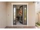 Inviting front door entrance featuring glass door with a view of a grand piano and brick accent wall at 1109 Castlevecchio Loop, Orlando, FL 32825