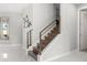 Modern staircase with wood steps, bronze railing, and art piece, with a view of the open floor plan at 1109 Castlevecchio Loop, Orlando, FL 32825
