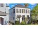 A stylish two-story home with dark shutters and a black awning over the windows at 1117 Damask St, Celebration, FL 34747