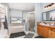 Well-lit bathroom with a soaking tub under a window and a separate glass-enclosed shower at 11506 Clair Pl, Clermont, FL 34711