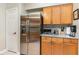 Stainless steel refrigerator stands against a backdrop of wood cabinets and granite counters at 11506 Clair Pl, Clermont, FL 34711
