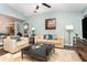 Bright living room with a ceiling fan, painting of a cityscape, comfortable beige furnishings and dark wood floors at 11506 Clair Pl, Clermont, FL 34711