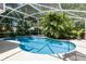 Beautiful screened-in pool area featuring lush tropical landscaping around the pool at 11506 Clair Pl, Clermont, FL 34711