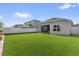 Lush backyard featuring green turf, a gray privacy fence, and a covered patio at 1210 Pando Loop, Orlando, FL 32824