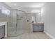 A well-lit bathroom with a walk-in shower, double vanity with gray cabinets, and tile flooring at 1210 Pando Loop, Orlando, FL 32824