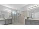 This is a bright bathroom featuring gray cabinets, a glass shower, and neutral tile at 1210 Pando Loop, Orlando, FL 32824