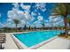 A large, luxurious community pool with sun loungers and lush landscaping at 1210 Pando Loop, Orlando, FL 32824