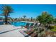 A community pool is surrounded by many lounge chairs, greenery, and neighborhood homes at 1210 Pando Loop, Orlando, FL 32824