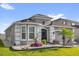 Charming gray home with well-manicured lawn, beautiful landscaping, and a brick-paved driveway at 1210 Pando Loop, Orlando, FL 32824