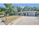 Neat home exterior with a well-maintained lawn, mature trees, and a long driveway at 132 W Lauren Ct, Casselberry, FL 32730