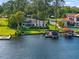 Aerial view of the waterfront property featuring a lush lawn, private dock, and boat lift at 1322 Palm Dr, Apopka, FL 32703