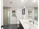 Modern bathroom with glass shower, gray tile floor, and white door leading to backyard with pool at 1322 Palm Dr, Apopka, FL 32703