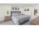 Bright bedroom with a gray upholstered bed, neutral walls, and framed artwork above the bedside tables at 1322 Palm Dr, Apopka, FL 32703