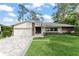 Beautiful home with brick accents, a well-manicured lawn, and a paved driveway at 1322 Palm Dr, Apopka, FL 32703