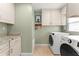 Laundry room with cream cabinets, granite counters, washer and dryer hookups, and a travertine tile floor at 1322 Palm Dr, Apopka, FL 32703