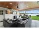Inviting outdoor living space with a waterfront view, ceiling fans, outdoor kitchen, and a tv for entertaining at 1322 Palm Dr, Apopka, FL 32703