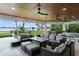Inviting outdoor living space with a seating area, outdoor kitchen, ceiling fans, and a waterfront view at 1322 Palm Dr, Apopka, FL 32703