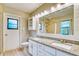 Bright bathroom featuring double sinks, granite countertops, and decorative mirror at 13245 Shore Dr, Winter Garden, FL 34787