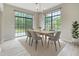 Dining area featuring large windows, modern chandelier, and a stylish table with seating for six at 13245 Shore Dr, Winter Garden, FL 34787