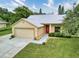 Charming single-story home with a well-manicured lawn, attached garage, and a bright red front door at 13245 Shore Dr, Winter Garden, FL 34787