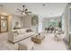 Open-concept living room with modern furnishings, ceiling fan, and ample natural light with dining room in background at 13245 Shore Dr, Winter Garden, FL 34787