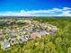 This aerial view highlights a community with a pond and mature trees surrounding single-Gathering homes in a neighborhood setting at 14001 Jomatt Loop, Winter Garden, FL 34787