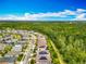 An aerial view highlights single Gathering homes nestled near a forested area, creating a sense of privacy and scenic beauty at 14001 Jomatt Loop, Winter Garden, FL 34787