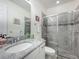 Modern bathroom with glass-enclosed shower, granite countertop, and ample lighting at 14001 Jomatt Loop, Winter Garden, FL 34787