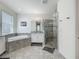 Bright bathroom featuring a soaking tub and a glass-enclosed shower with tiled walls at 14001 Jomatt Loop, Winter Garden, FL 34787