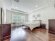 Well-lit bedroom featuring hardwood floors, a large window, and tasteful decor at 14001 Jomatt Loop, Winter Garden, FL 34787
