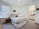 Cozy bedroom with natural light, soft bedding, and a view into the en-suite bathroom at 14001 Jomatt Loop, Winter Garden, FL 34787