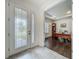 Bright foyer with decorative glass front door, tile flooring, and an office with hardwood floors at 14001 Jomatt Loop, Winter Garden, FL 34787