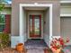 Inviting front entrance with a decorative glass door, brick pavers, and colorful potted plants at 14001 Jomatt Loop, Winter Garden, FL 34787