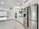 Stainless steel refrigerator and range hood in a bright white kitchen at 14001 Jomatt Loop, Winter Garden, FL 34787