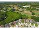 This aerial view reveals a neighborhood near a golf course, ponds, and sports courts in a serene setting at 145 Circle Hill Rd, Sanford, FL 32773