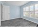 Bedroom with light blue walls, gray laminate flooring, a large window with blinds, and a white door at 145 Circle Hill Rd, Sanford, FL 32773